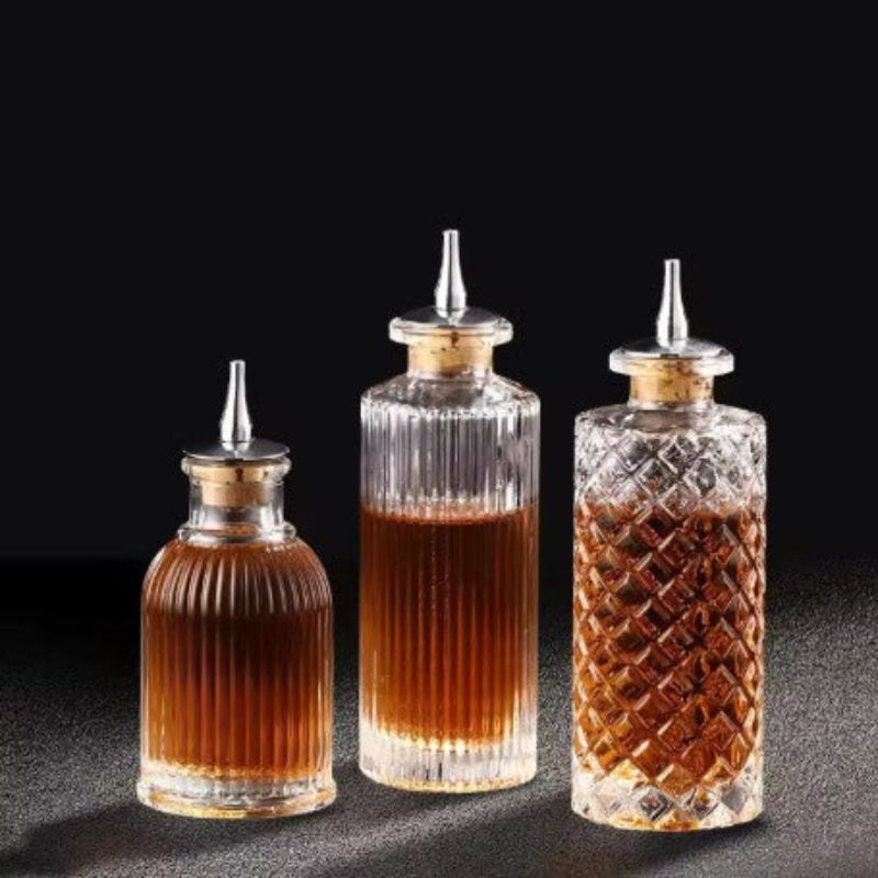 Three glass bottles with liquid and decorative caps on a dark background