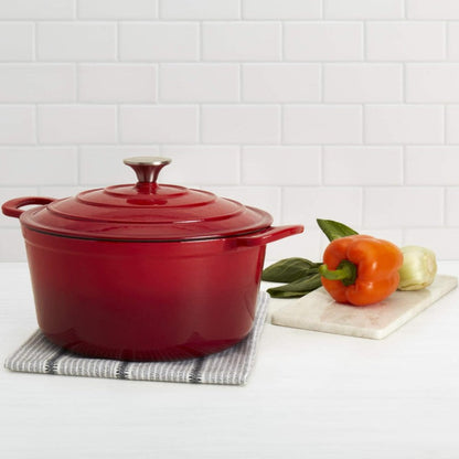 Red cast iron Dutch oven on a white surface with a white tiled wall background