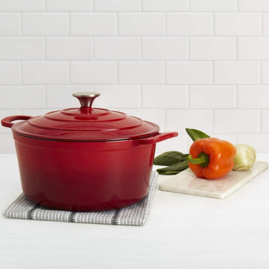Red cast iron Dutch oven on a white surface with a white tiled wall background