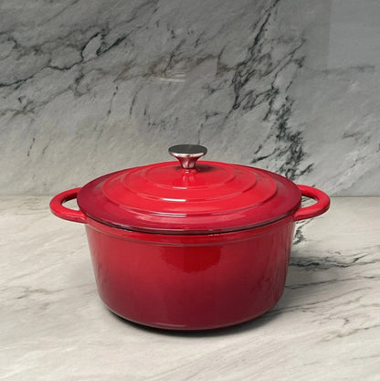 Red enameled cast iron Dutch oven on a marble surface