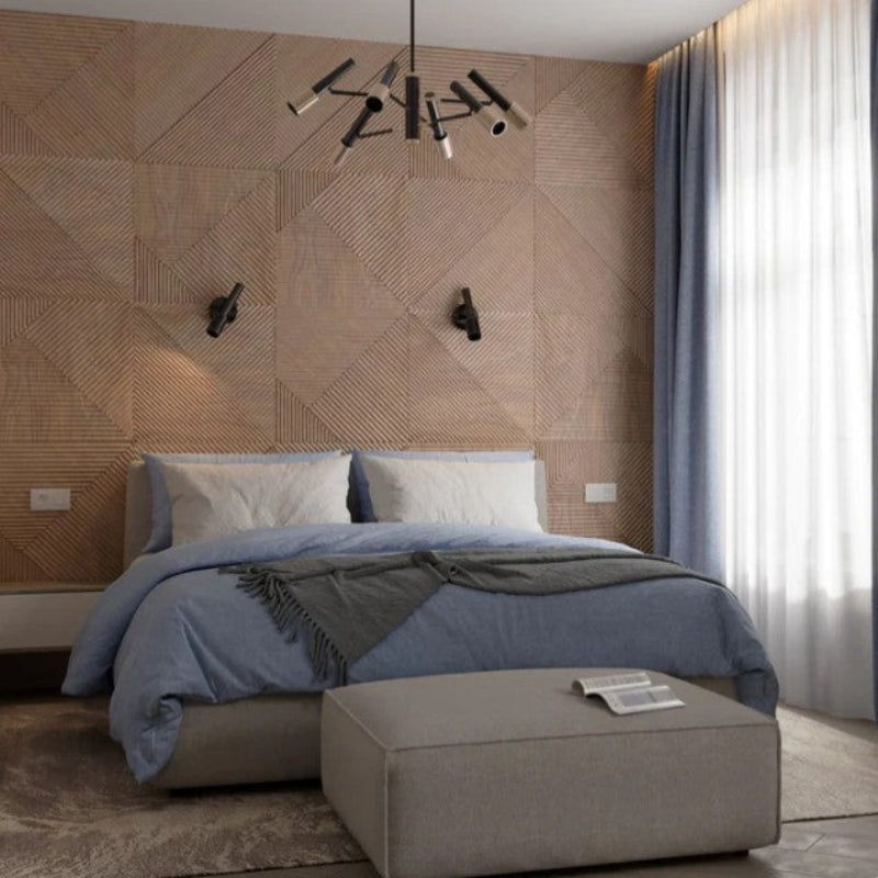 Modern bedroom with geometric wall design, bed, and ottoman.