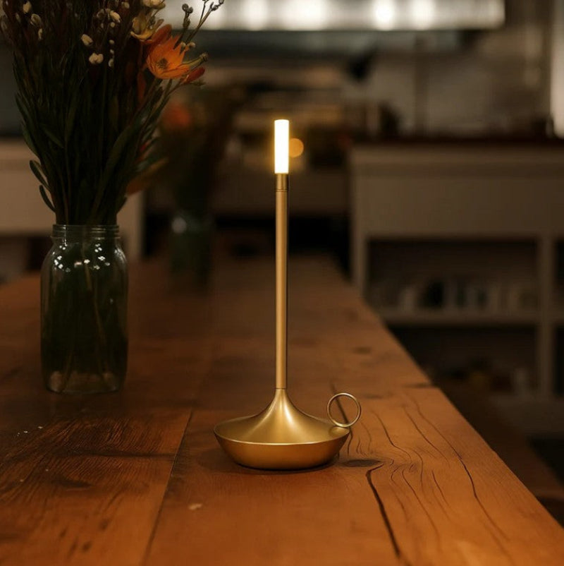 Gold candle holder on a wooden table with a blurred background