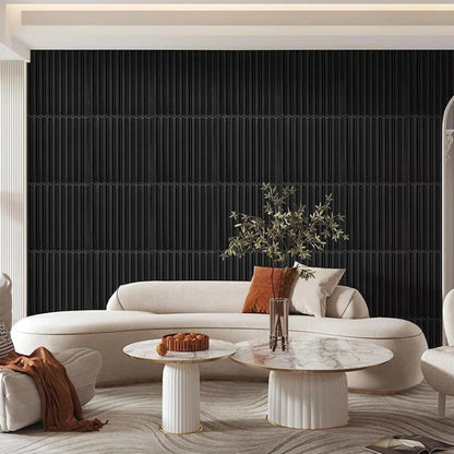 Modern living room with a white sofa, marble coffee table, and decorative elements against a black paneled wall.