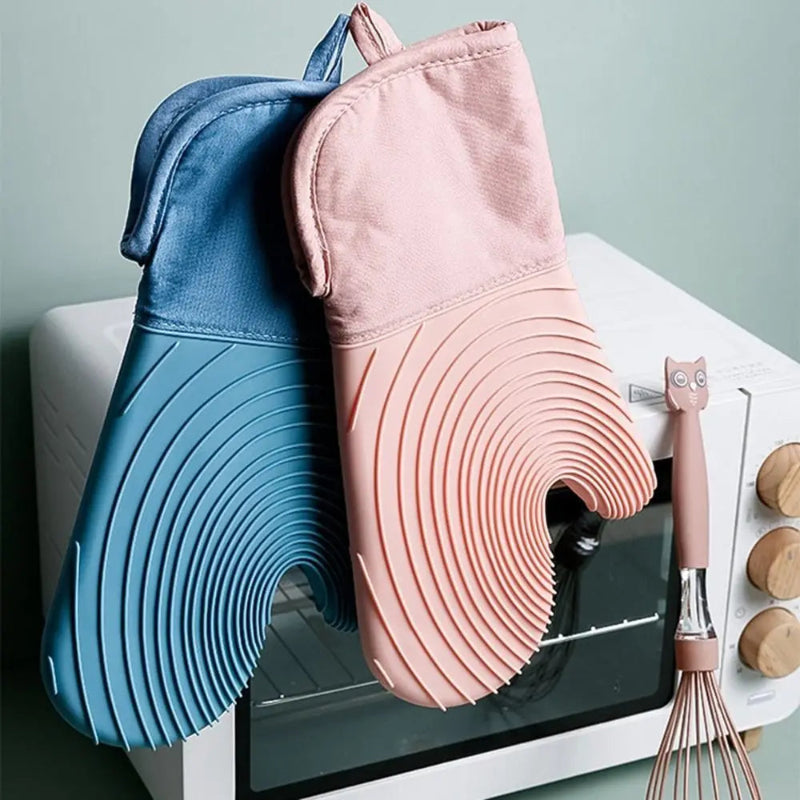 Blue and pink silicone baking mats on a white surface with kitchen tools.