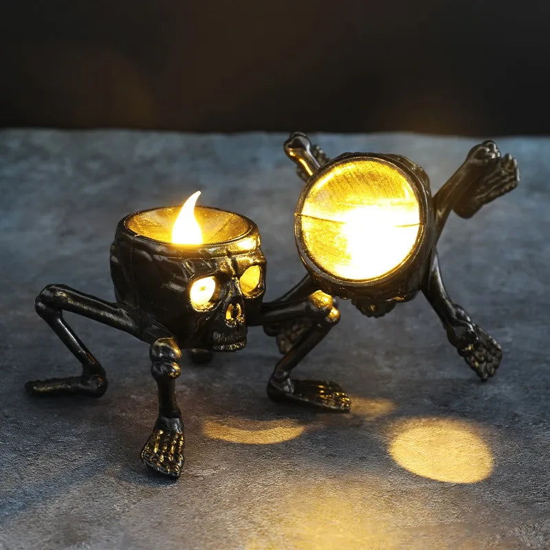Two skeletal candle holders with lit candles