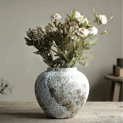 Decorative vase with artificial flowers on a wooden surface