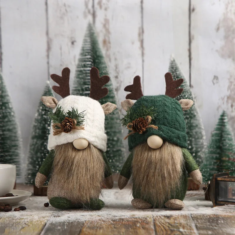 Two festive gnomes with winter hats and antlers on a wooden surface with Christmas trees in the background.