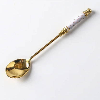 Gold spoon with a decorative handle on a white background