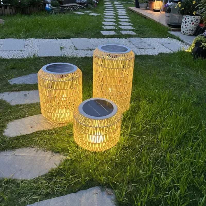 Three solar-powered outdoor lights on a grassy area with stepping stones.