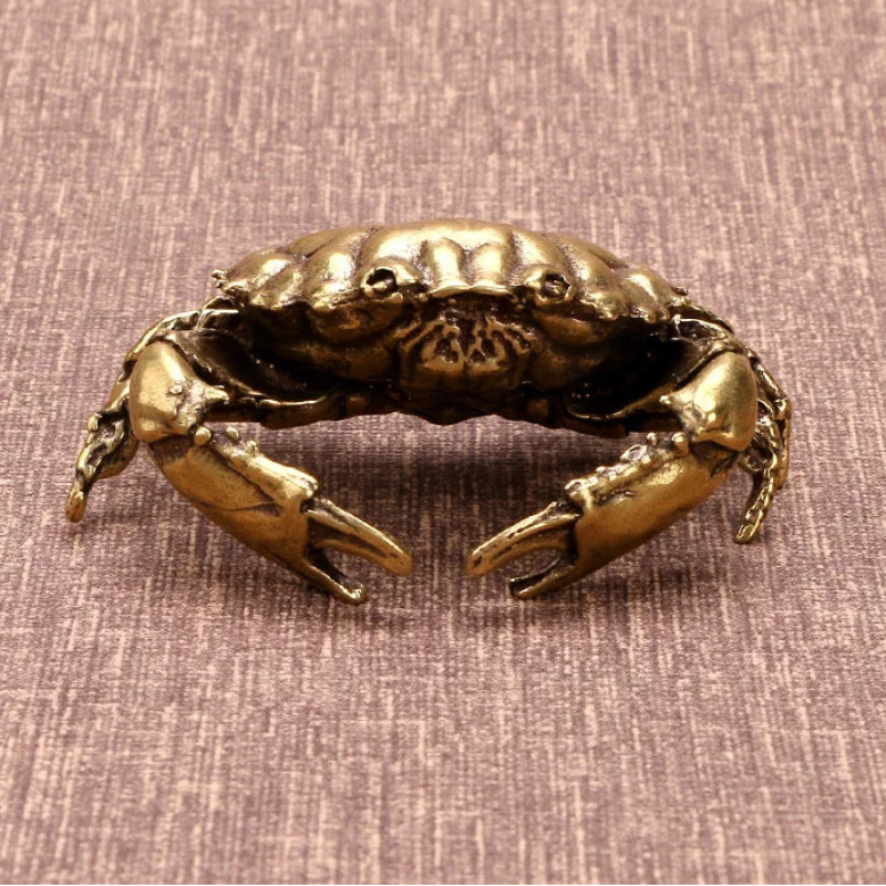 Bronze crab sculpture on a textured brown background