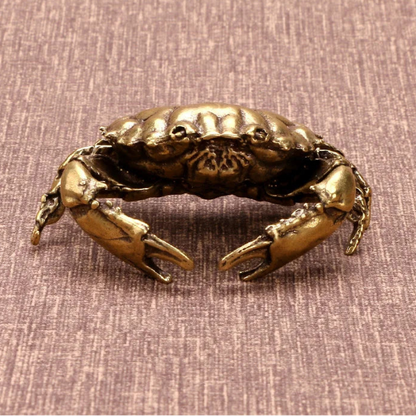 Bronze crab sculpture on a textured brown background