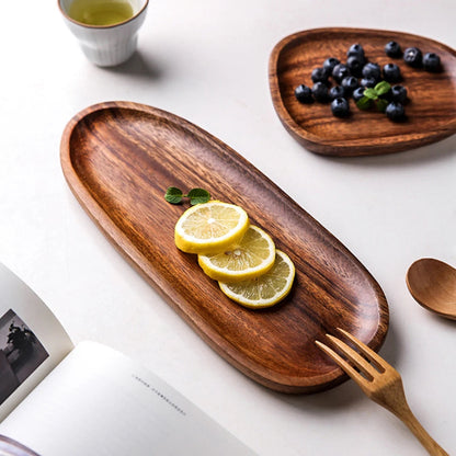 Oval wooden serving tray with lemon slices, and a second tray with blueberries.