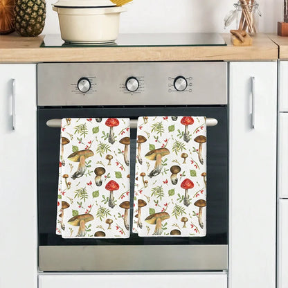 Stainless steel oven with mushroom-patterned towels on a kitchen counter.