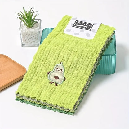 Green textured dish towel with avocado design and Textile Boutique label on a white surface.