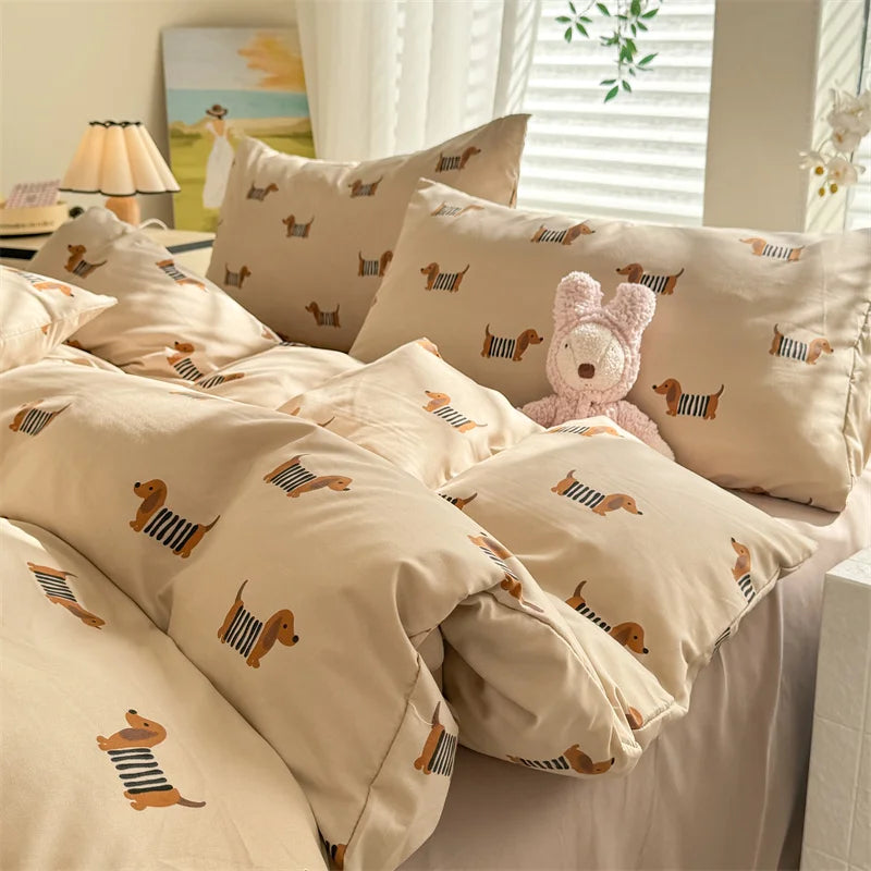 Beige bedding set with dachshund pattern on a bed with a teddy bear.