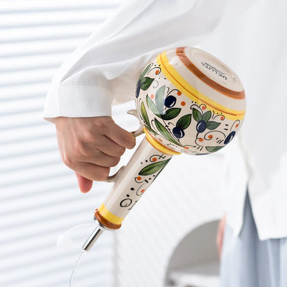 Decorative hand mixer held by a person with a white background