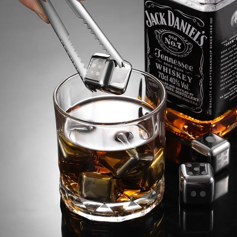 Jack Daniel's whiskey bottle with a glass of whiskey and ice cubes on a gray background