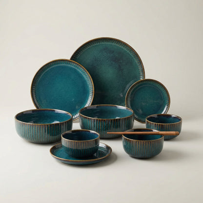Set of blue ceramic dinnerware with brown accents on a light gray background