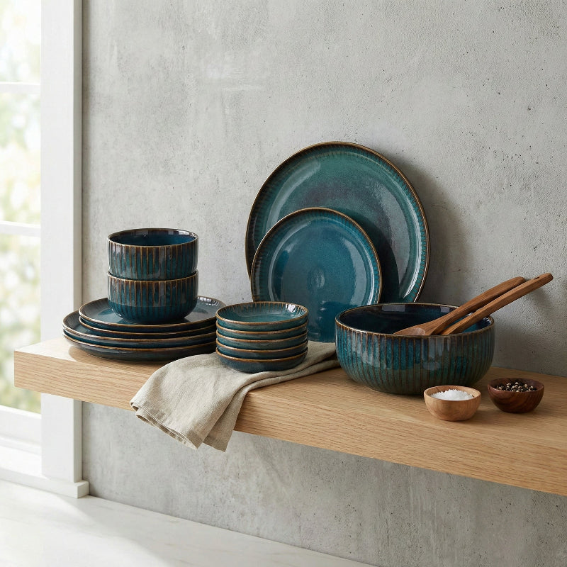 Set of blue ceramic dishes on a wooden shelf with a neutral background