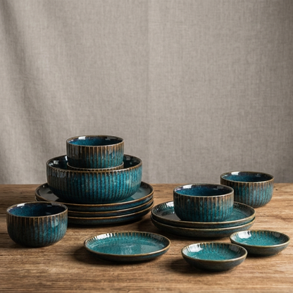 Teal kiln-glazed ceramic dinnerware set stacked on a wood table, Kiyo Home