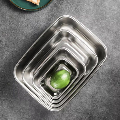 Five nested rectangular stainless steel containers, with a green lime in the smallest one.