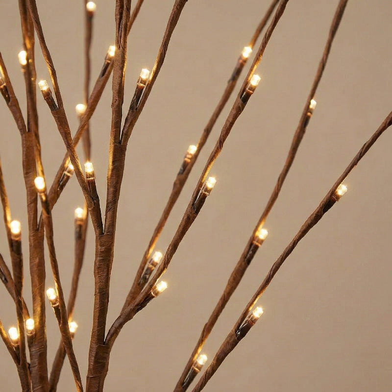 Decorative branch with small lights against a neutral background
