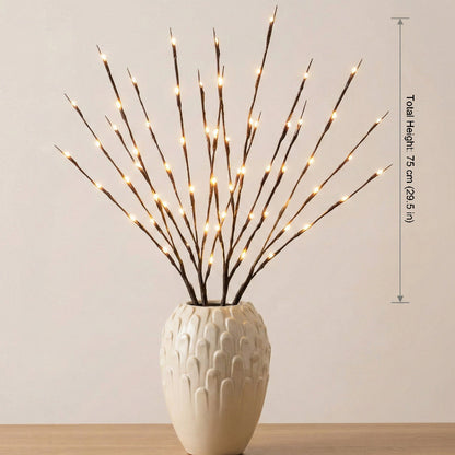 Decorative branches with lights in a white vase on a wooden surface with a neutral background