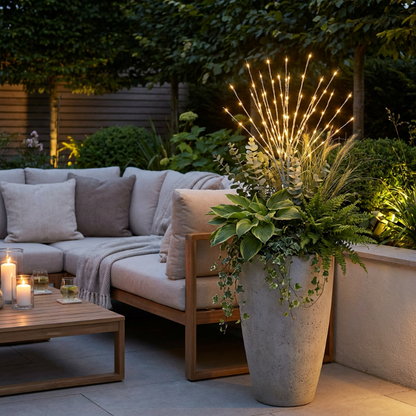 Outdoor patio setting with a sectional sofa, potted plant, and decorative lights.