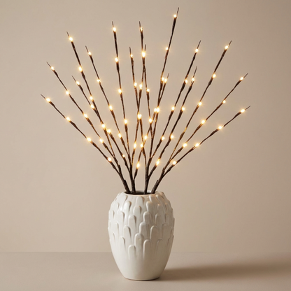 Decorative branches with lights in a white textured vase on a beige background