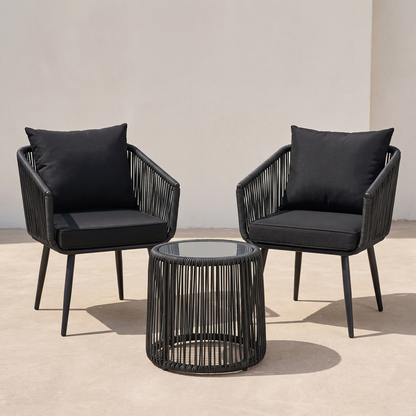 Two black chairs with cushions and a matching table on a beige floor.