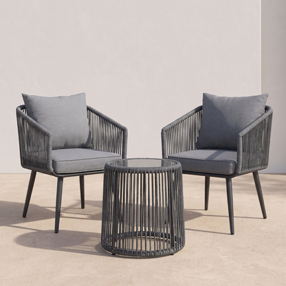 Two gray chairs with cushions and a matching round table on a neutral background