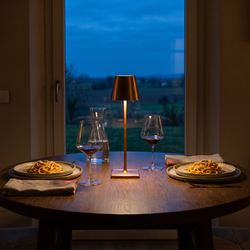 Allegra dimmable cordless table lamp on outdoor dining table at dusk