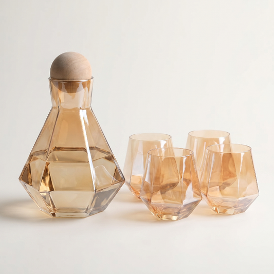 Amber modern faceted glass decanter and tumbler set on white background