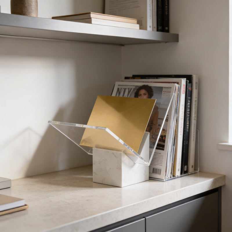 Modern bookend with gold book on a shelf with magazines