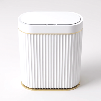 White ribbed automatic smart sensor trash can with gold trim and infrared sensor lid on a clean off-white background
