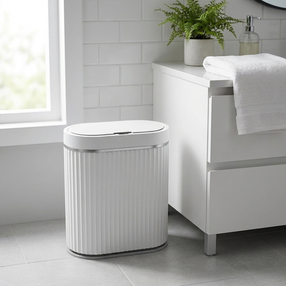 White automatic smart sensor trash can styled in a bright modern bathroom
