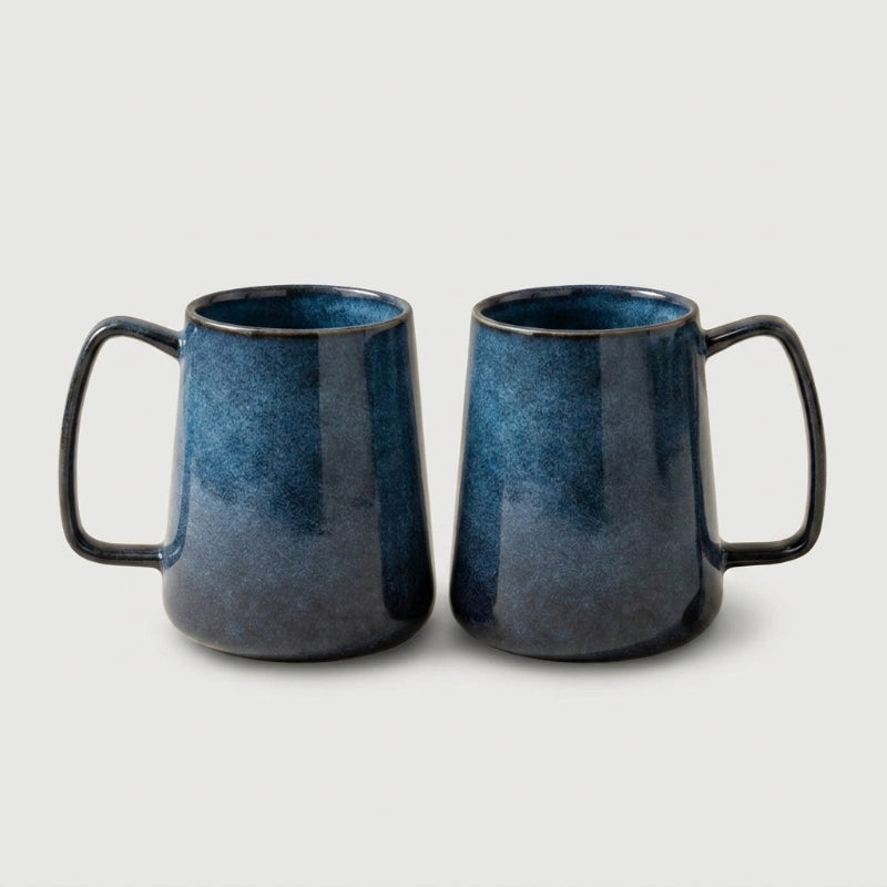 Set of two azure blue pottery mugs on white background