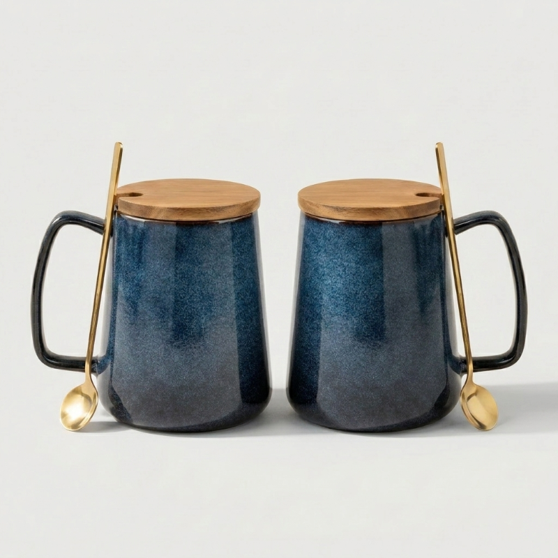 Two blue ceramic mugs with wooden lids and gold spoons on a light gray background