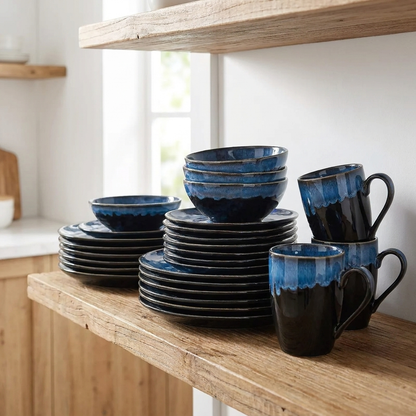 Black and blue glazed ceramic dinnerware stacked on a kitchen shelf