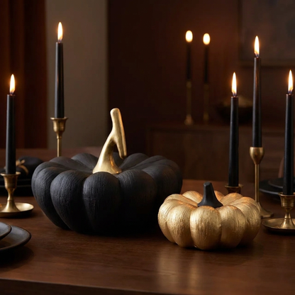 Black and gold decorative pumpkins with black taper candles in a moody fall display