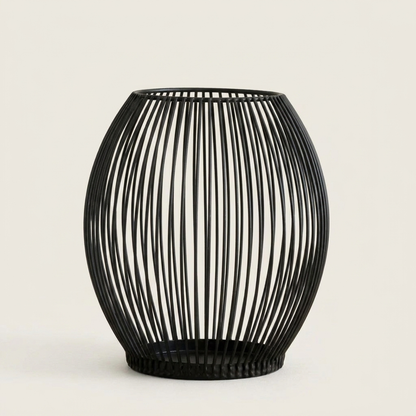 Black iron wire cage candleholder on a clean off-white background