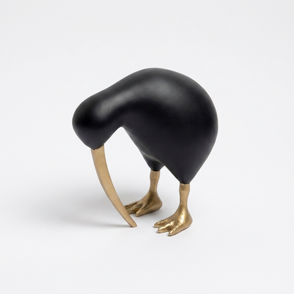 Black Kiwi Bird Sculpture with matte black body and gold-tone beak and feet on a plain background