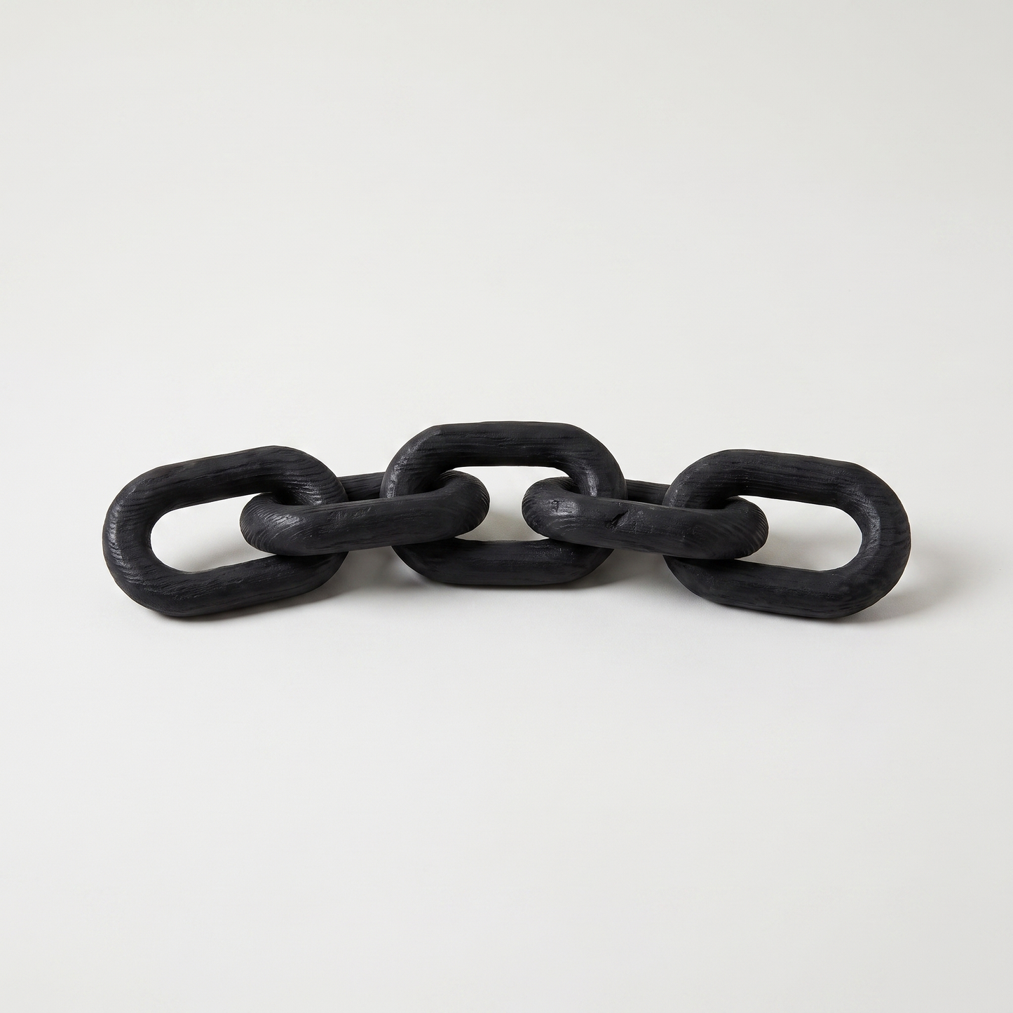 Black wooden decorative chain with five hand-carved links and a matte black finish on a clean off-white background