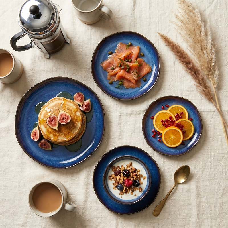 Blue wave edge ceramic dinner plates with plated appetizers on dining table