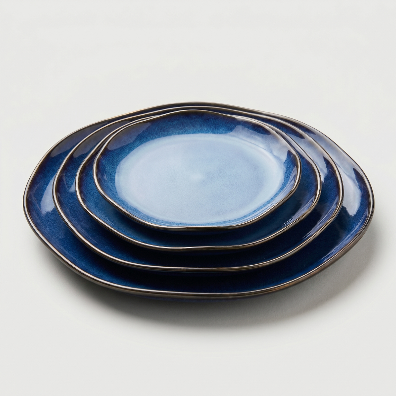 Blue wave edge ceramic dinner plates stacked on white background
