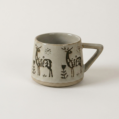 Botanical ceramic coffee mug with a hand-painted deer design on a clean off-white background