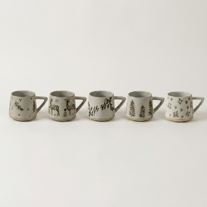 Set of botanical ceramic coffee mugs in five hand-painted designs on a clean off-white background