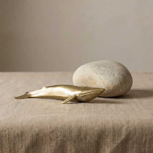 Brass blue whale sculpture with a smooth metallic finish, styled as a modern decorative accent