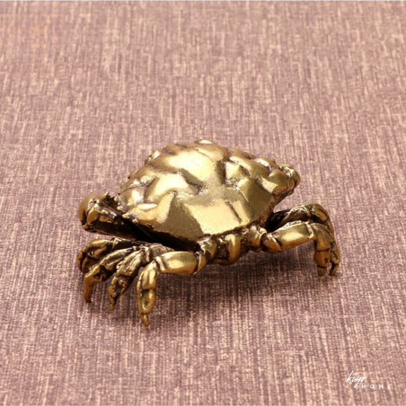 Bronze crab decorative item on a textured brown background