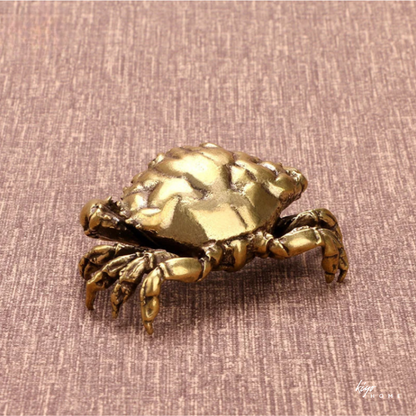 Bronze crab decorative item on a textured brown background